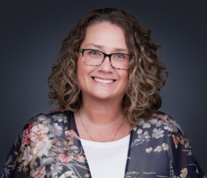 Professional corporate headshot of a DFW business director against a studio backdrop